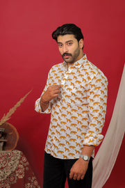 Man wearing a white tiger printed full sleeve shirt with black jeans against a red background.